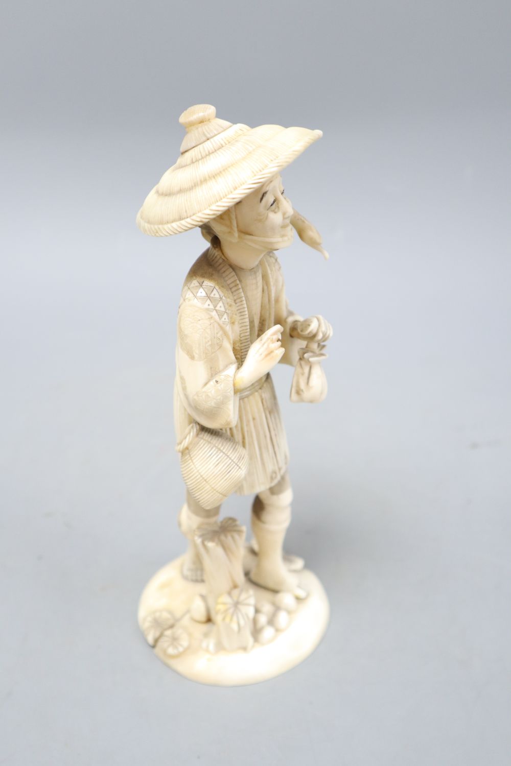 A Japanese sectional walrus ivory figure of a cormorant fisherman, character marks to base, height 23cm